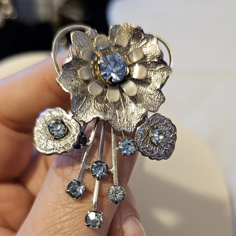Silvertone and blue rhinestone flower brooch with rivets